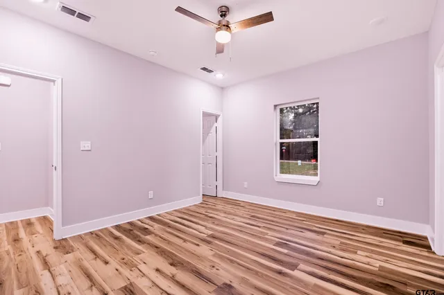 a view of a livingroom with wooden floor and a ceiling fan