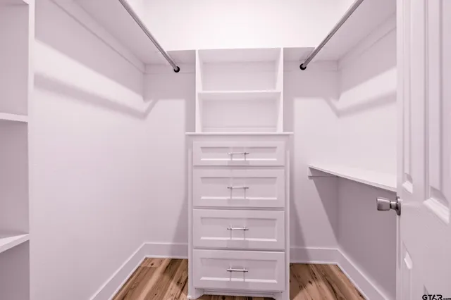 a view of walk in closet with empty racks
