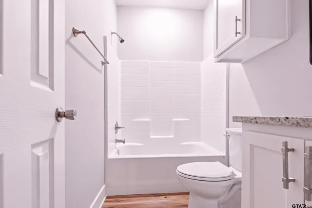 a bathroom with a granite countertop toilet sink and shower