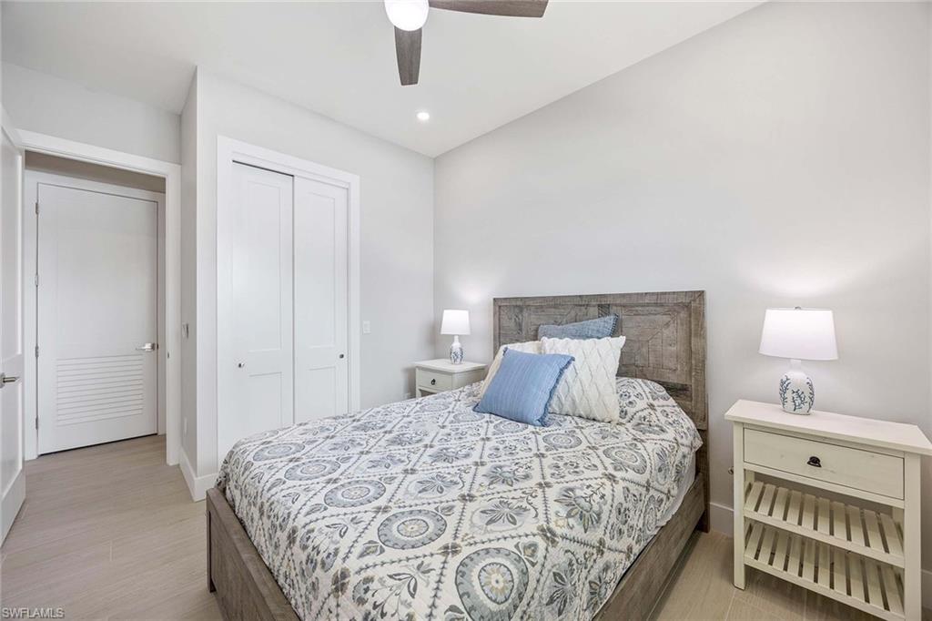 1395 Curlew Avenue, Unit 43 Naples, FL 34102 - Photo 15 of 24 a bedroom with a large bed and a chandelier