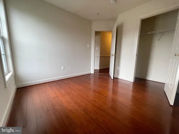 an empty room with wooden floor and bathroom