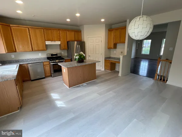 a kitchen with stainless steel appliances granite countertop a stove refrigerator sink and microwave