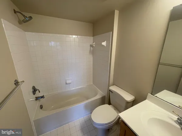 a white toilet and tub sitting next to a bathroom sink