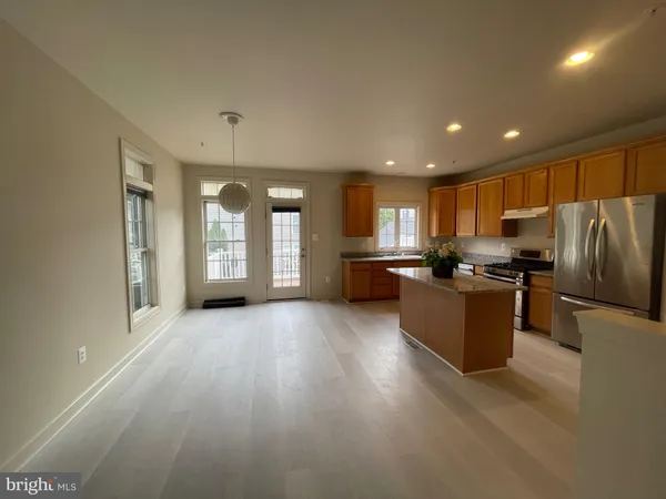a view of kitchen with refrigerator stove and wooden cabinets