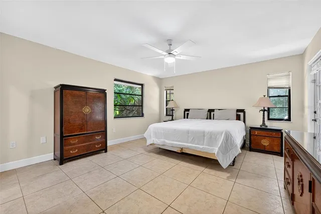 a spacious bedroom with a bed and a lamp on a dresser