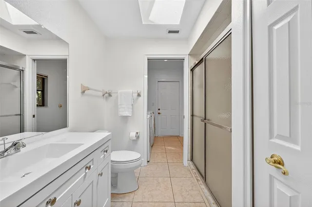 a bathroom with a granite countertop sink toilet a mirror and shower