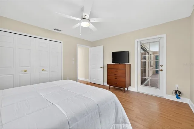 a bedroom with a bed and a flat tv screen on dresser