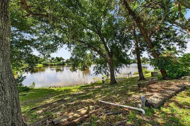 a backyard of a house with lots of green space and lake view in back