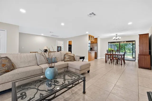 a living room with furniture and a dining table with kitchen view