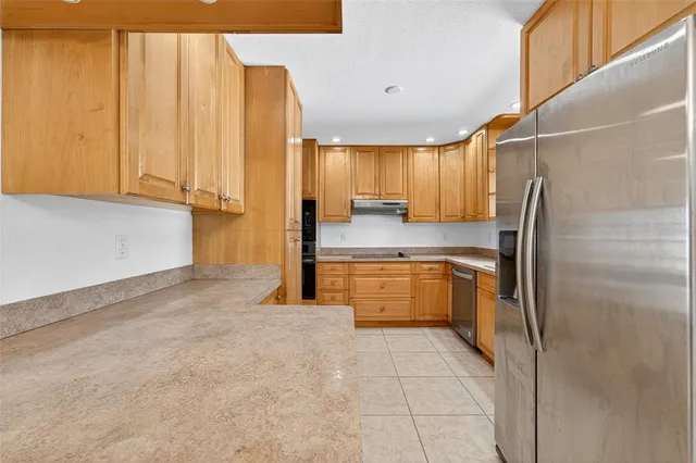 a kitchen with a refrigerator a sink and cabinets