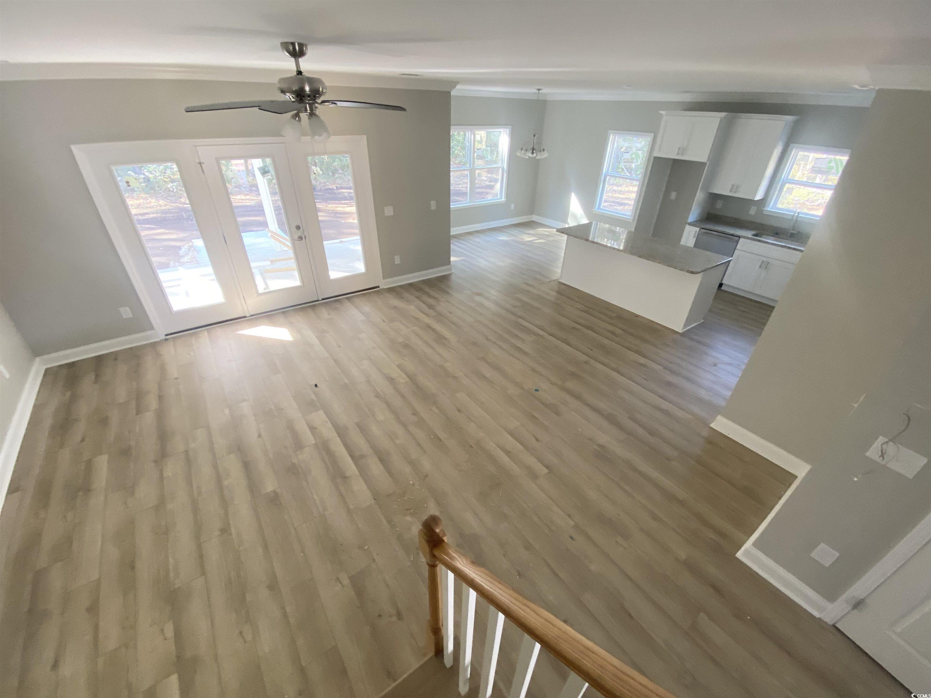 5553 Grape Arbor Lane Myrtle Beach, SC 29588 - Photo 16 of 35 Unfurnished living room featuring light wood finished floors, crown molding, ceiling fan, and a chandelier