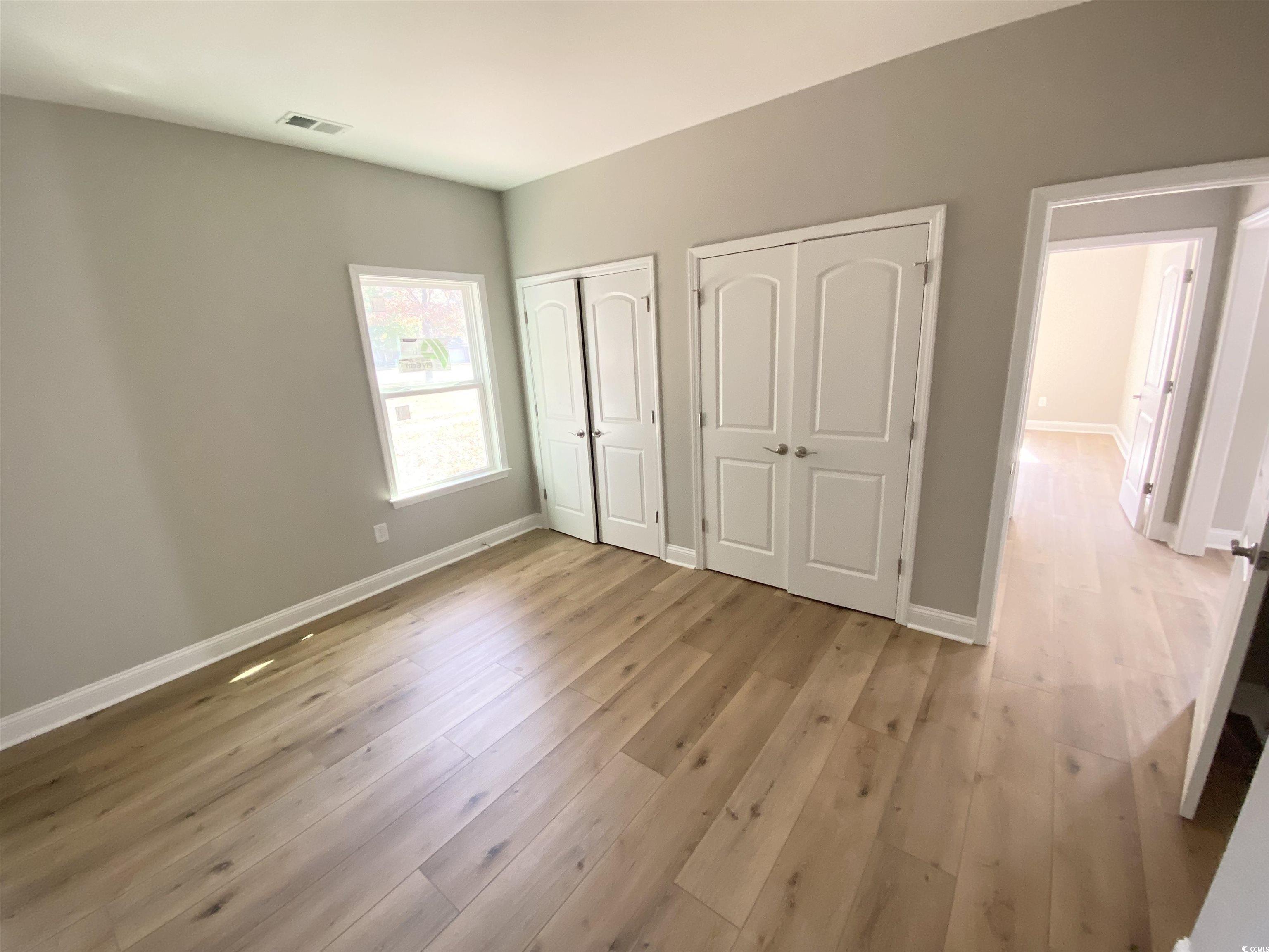 5553 Grape Arbor Lane Myrtle Beach, SC 29588 - Photo 24 of 35 Guest bedroom featuring two closets and light wood-style flooring