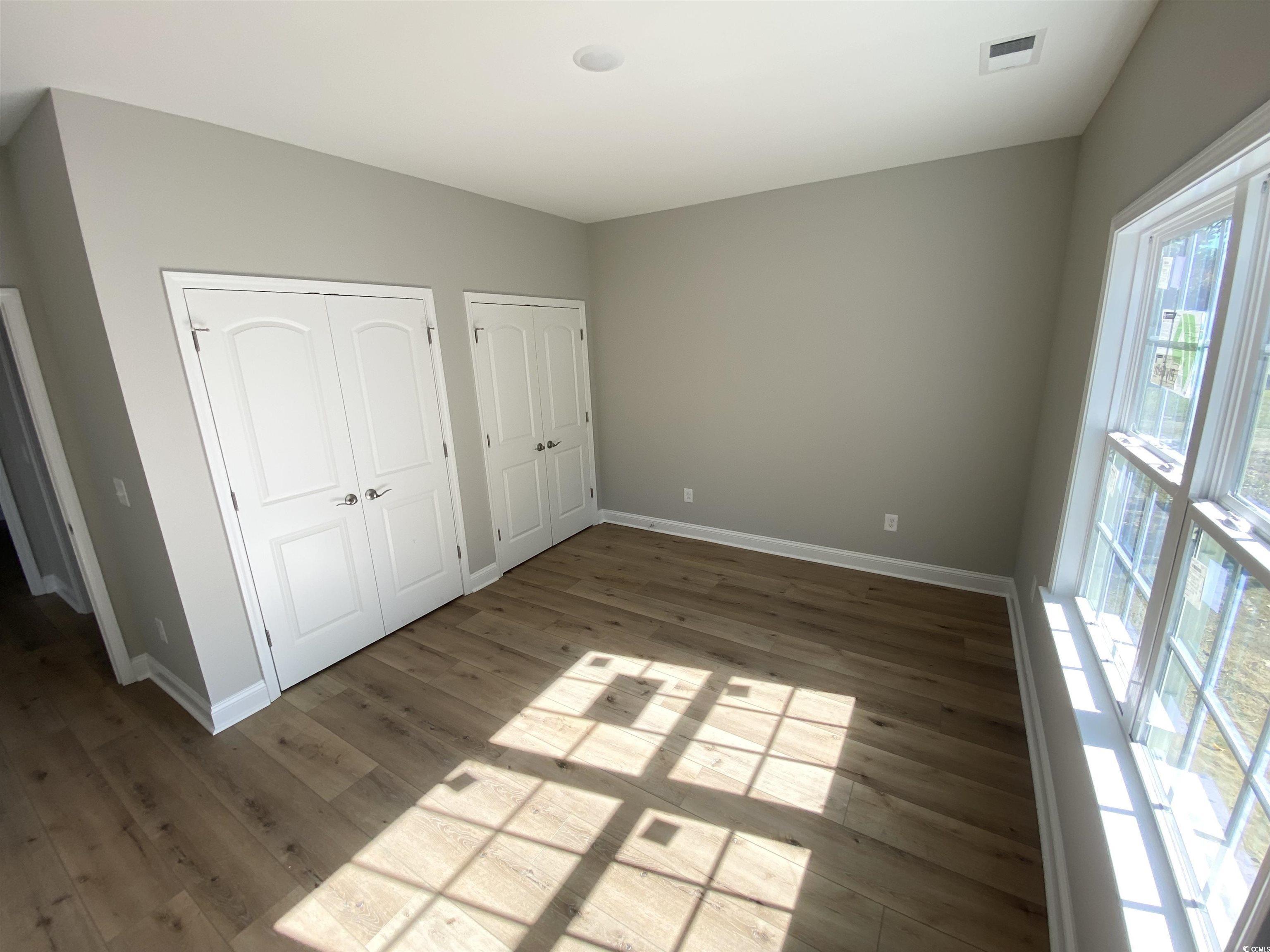 5553 Grape Arbor Lane Myrtle Beach, SC 29588 - Photo 26 of 35 Guest bedroom with multiple closets and wood finished floors