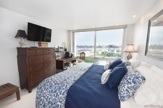 a large bedroom with a bed and flat screen tv
