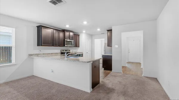 a view of kitchen with stainless steel appliances granite countertop refrigerator sink and cabinets