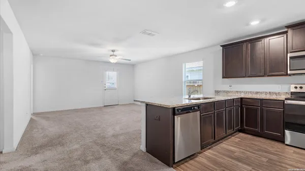 a kitchen with stainless steel appliances granite countertop a sink stove and cabinets