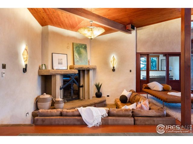 a living room with furniture a large window and stainless steel appliances