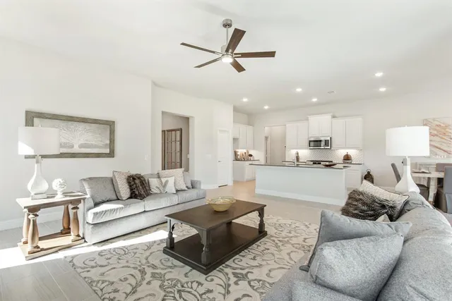 a living room with furniture and kitchen view