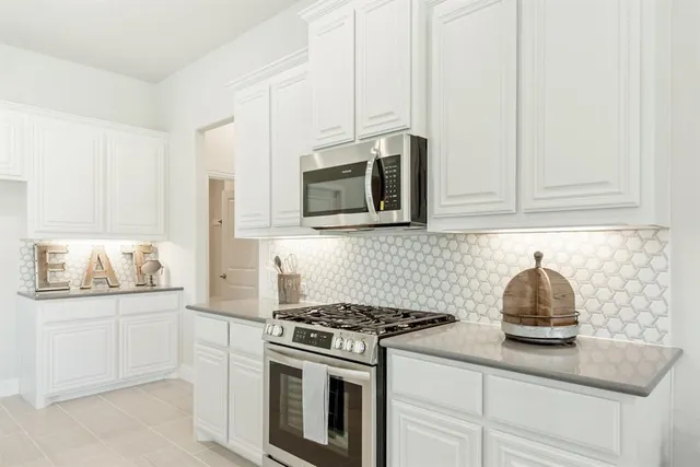 a kitchen with kitchen island granite countertop a sink stove and cabinets