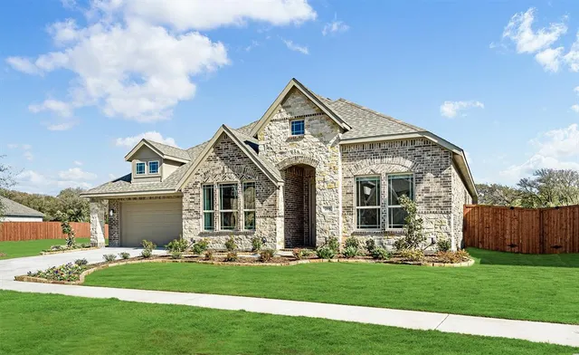 a front view of a house with a garden and plants