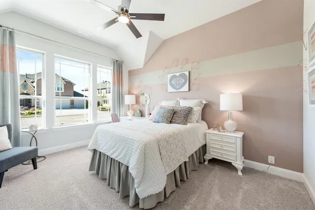 a bedroom with a bed a lamp and a large window