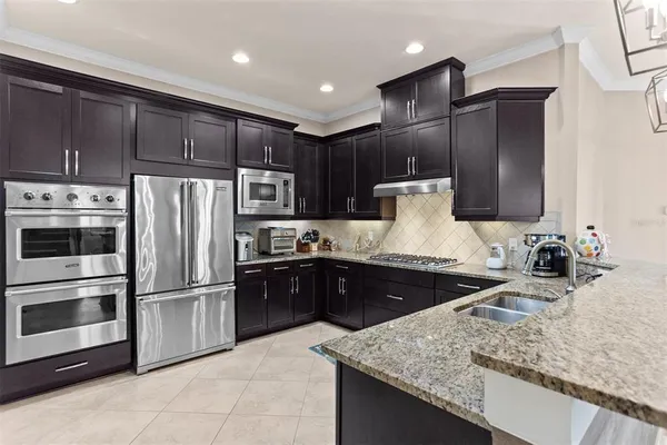 a kitchen with stainless steel appliances kitchen island granite countertop a refrigerator stove and oven