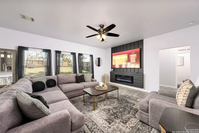 a living room with furniture a flat screen tv and a large window
