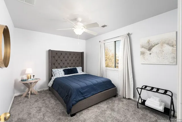 a bedroom with a bed and a painting on the wall