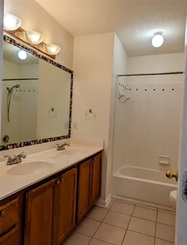 a bathroom with a granite countertop sink a mirror and a bathtub