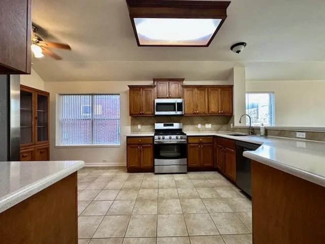 a large kitchen with stainless steel appliances granite countertop a stove a sink and a microwave
