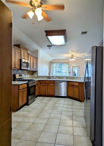 a large kitchen with a stove a sink dishwasher and a refrigerator