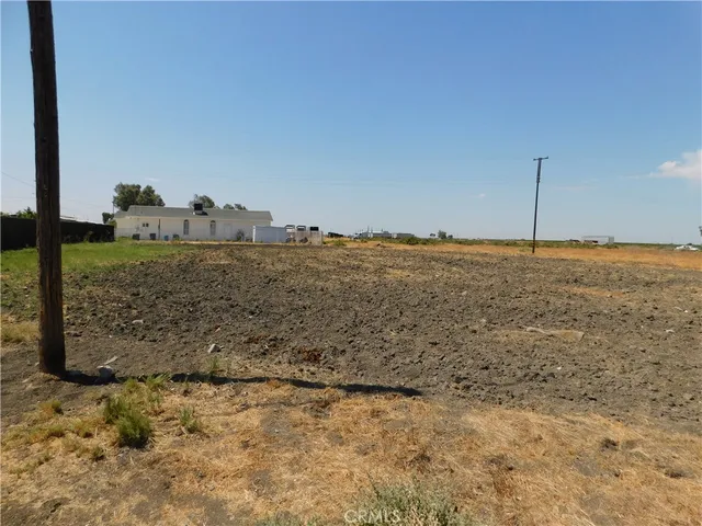 a view of a dry yard with wooden fence