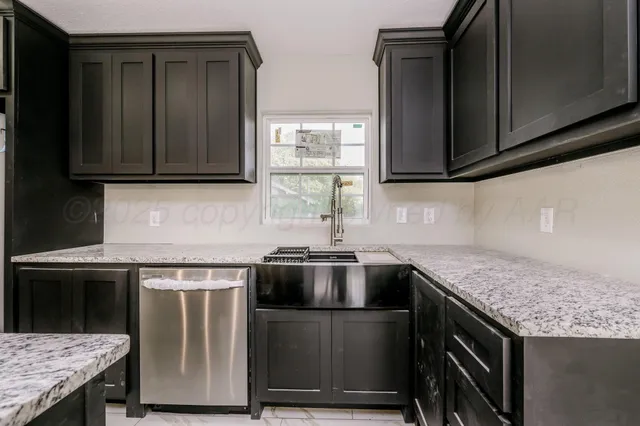 a kitchen with granite countertop a stove and a sink