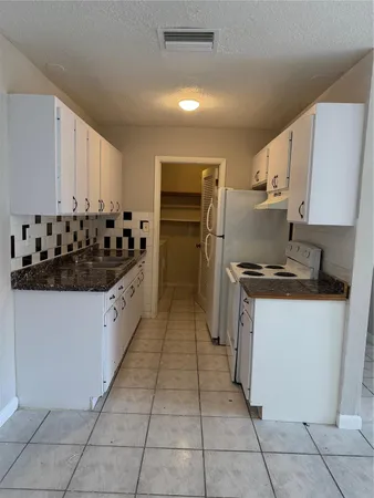a kitchen with stainless steel appliances granite countertop a refrigerator and a stove