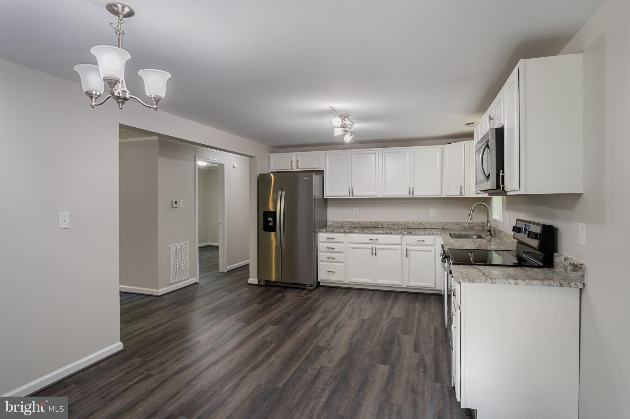 14408 Old Ridge Road Beaverdam, VA 23015 - Photo 12 of 26 a kitchen with stainless steel appliances granite countertop a refrigerator a stove and a wooden floors