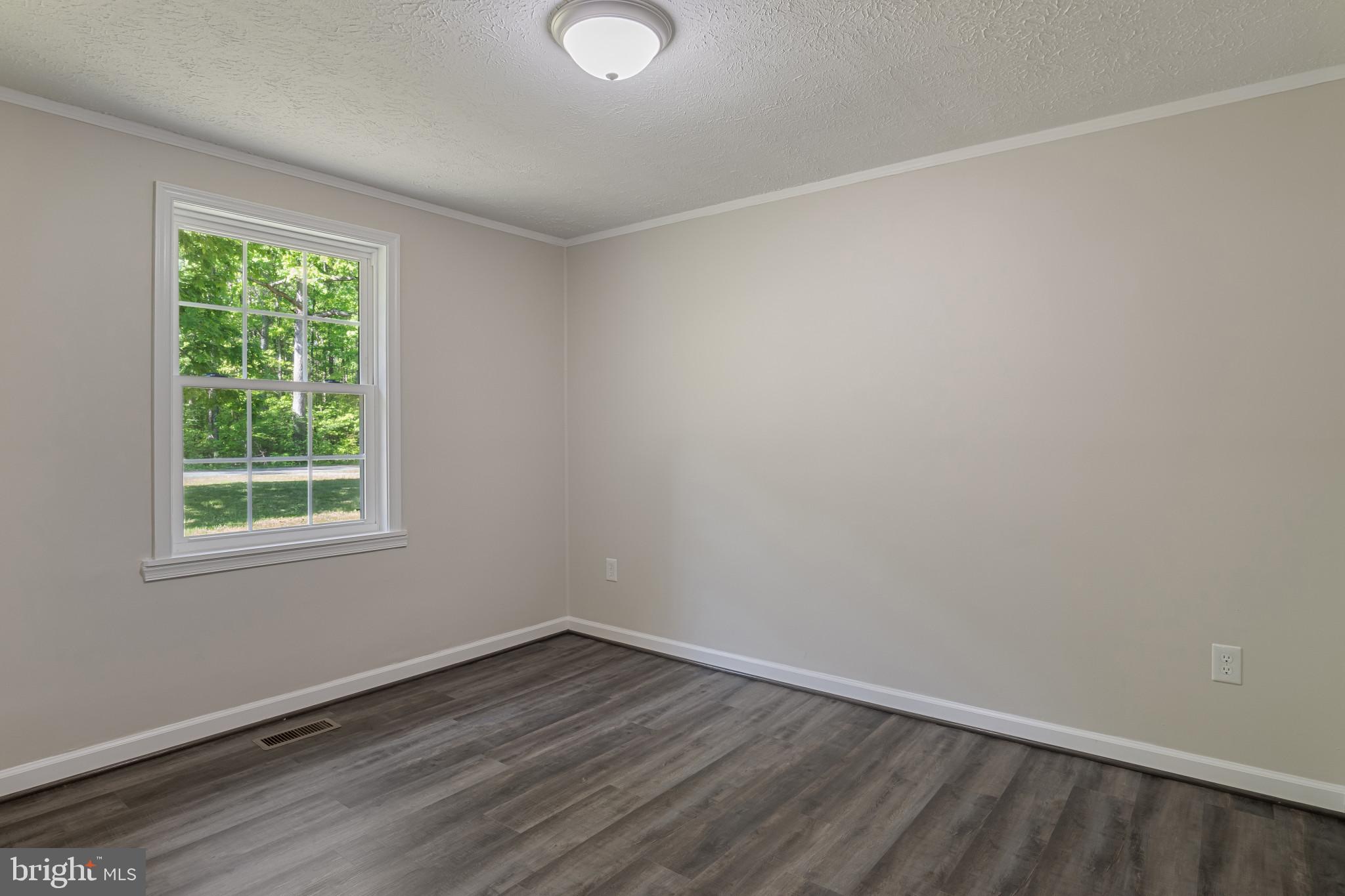 14408 Old Ridge Road Beaverdam, VA 23015 - Photo 18 of 26 an empty room with wooden floor and windows