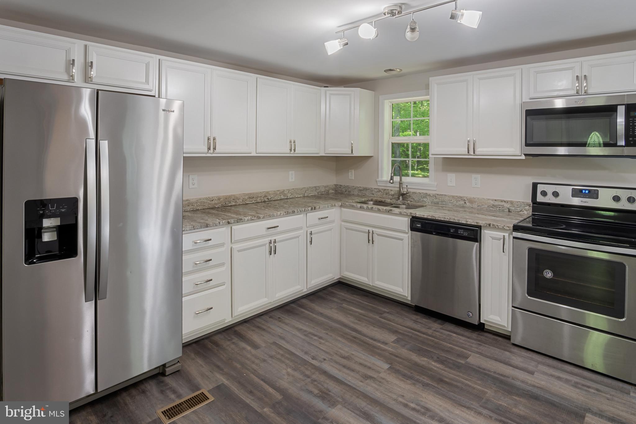 14408 Old Ridge Road Beaverdam, VA 23015 - Photo 9 of 26 a kitchen with stainless steel appliances a refrigerator sink and microwave