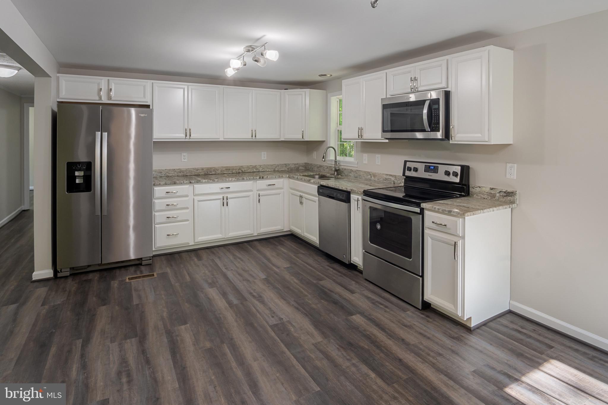 14408 Old Ridge Road Beaverdam, VA 23015 - Photo 10 of 26 a kitchen with granite countertop a refrigerator stove top oven and sink