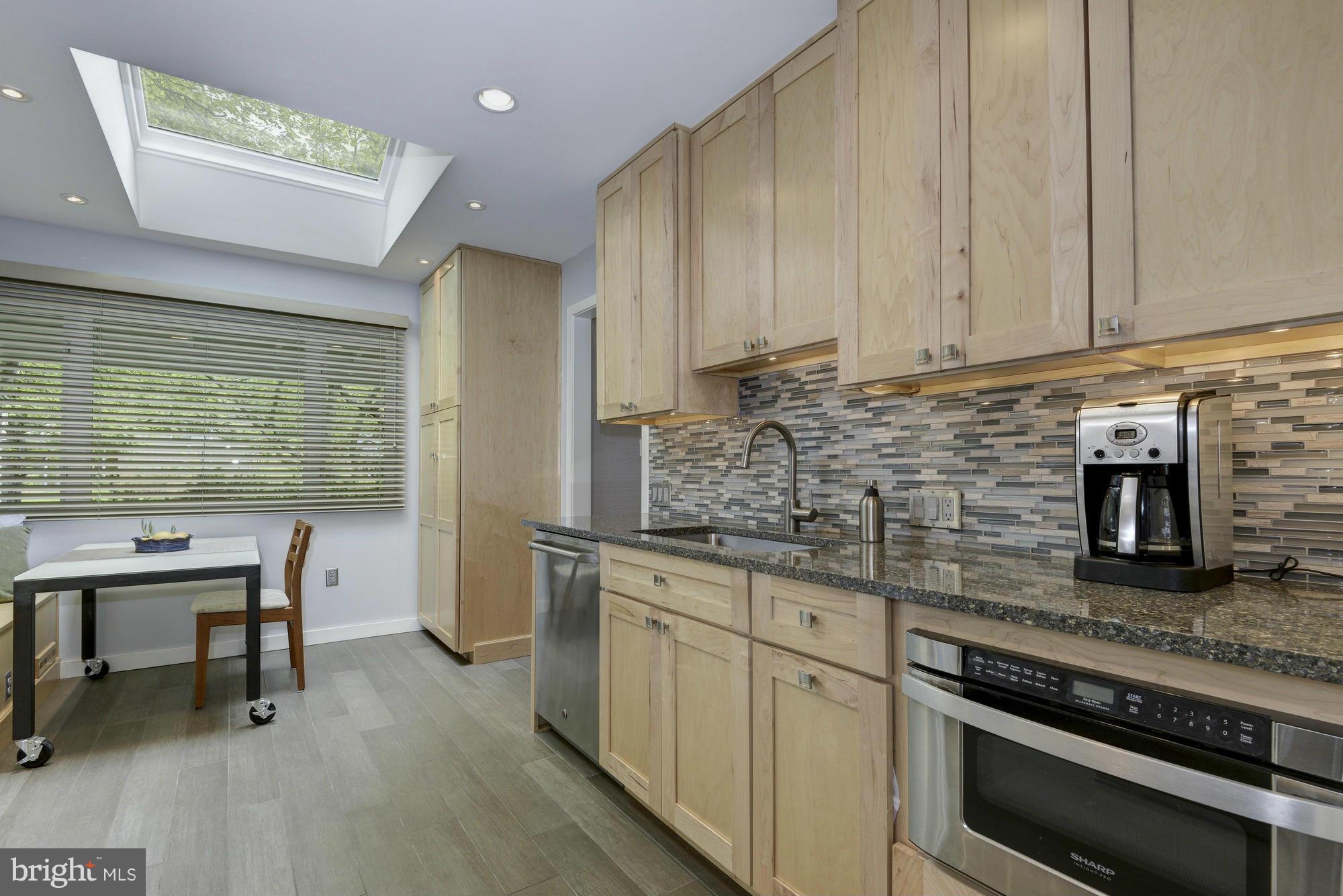 10823 Margate Road Silver Spring, MD 20901 - Photo 11 of 30 a kitchen with stainless steel appliances granite countertop a stove a sink and a microwave