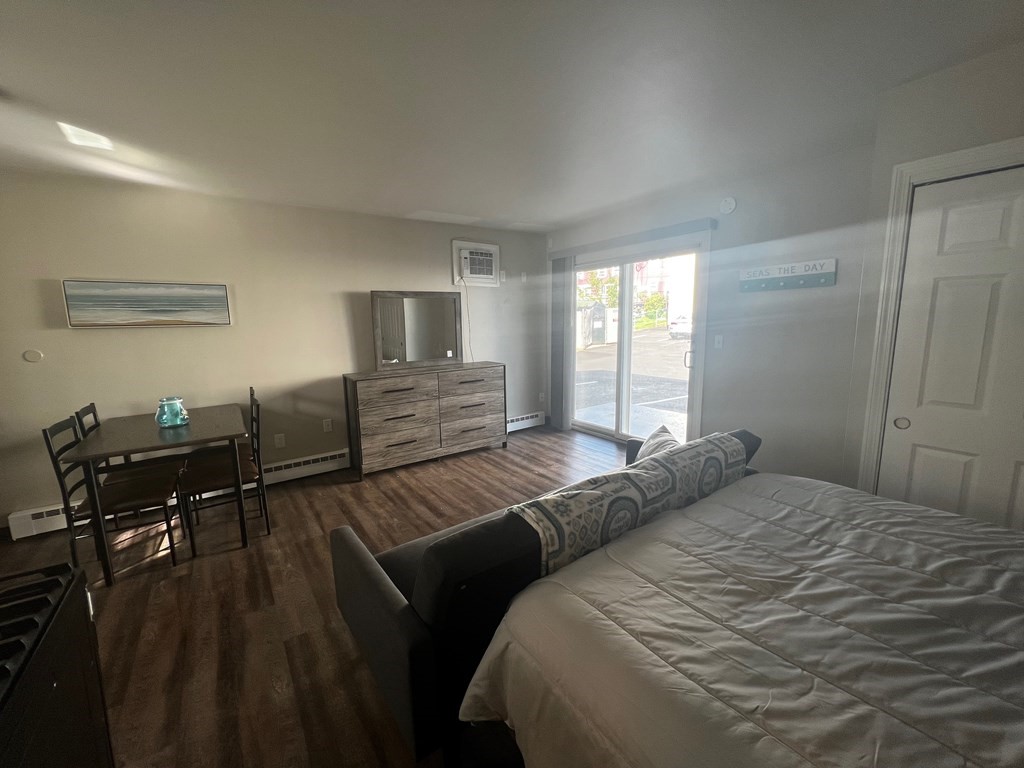 933 Ocean Boulevard, Unit 27 Hampton, NH 03842 - Photo 6 of 9 a bedroom with a bed and wooden floor