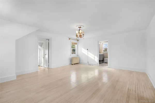 a view of a livingroom with wooden floor and a large window