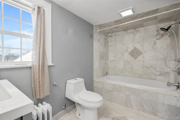a white toilet sitting next to a bath tub shower