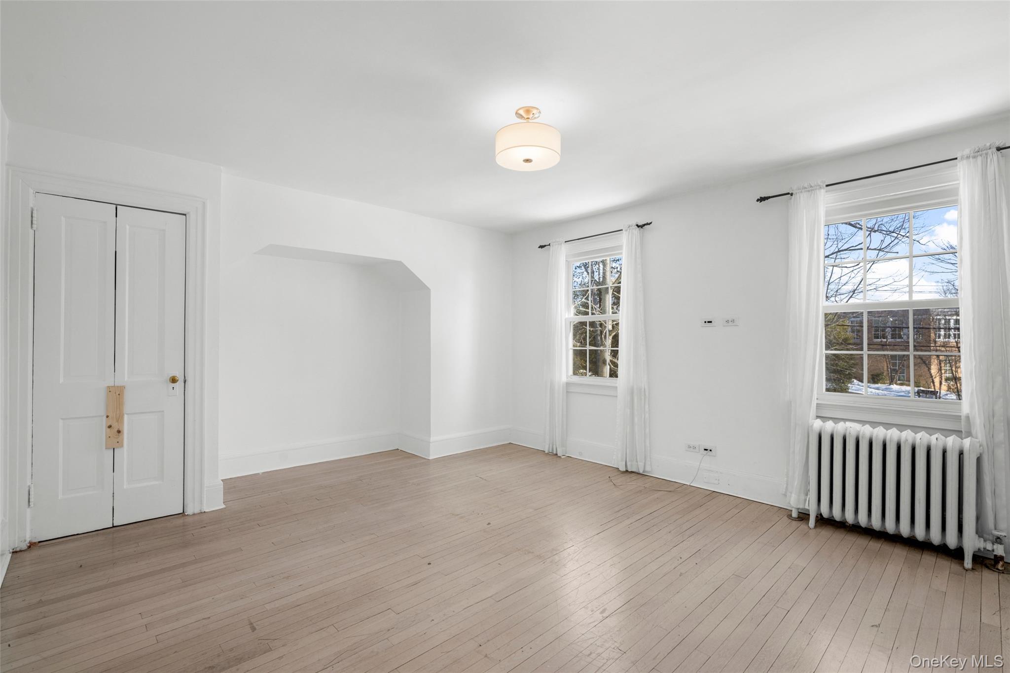 1146 North Avenue New Rochelle, NY 10804 - Photo 45 of 50 an empty room with wooden floor and windows