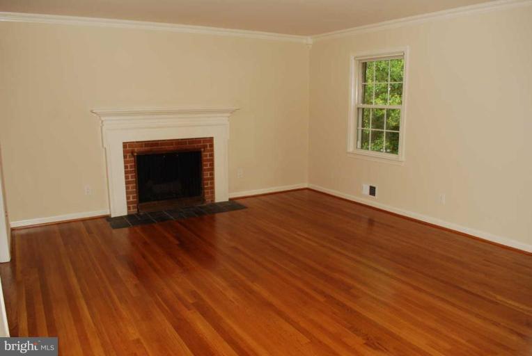 1904 Old Stage Road Alexandria, VA 22308 - Photo 3 of 21 an empty room with wooden floor and a fireplace