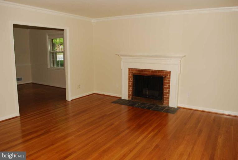1904 Old Stage Road Alexandria, VA 22308 - Photo 4 of 21 an empty room with wooden floor and fireplace