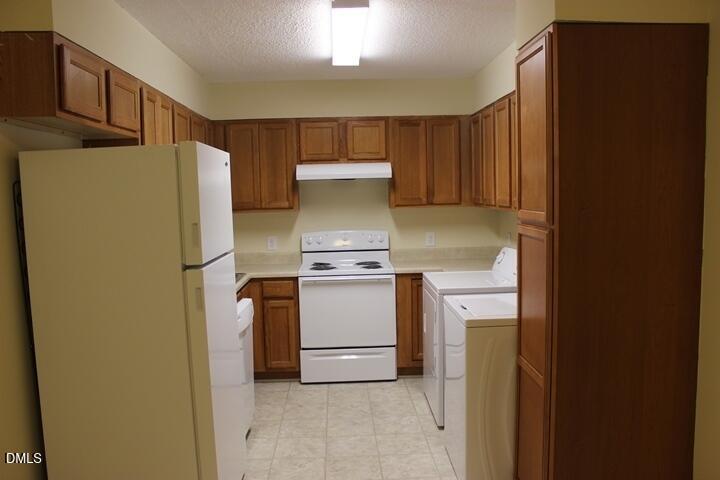 203 East Ransom Street, Unit 3D Fuquay-Varina, NC 27526 - Photo 2 of 10 a kitchen with a refrigerator sink stove and cabinets