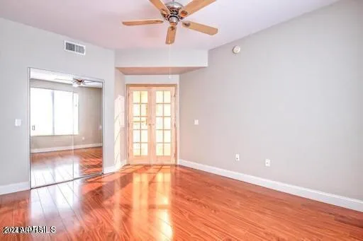 an empty room with wooden floor and windows