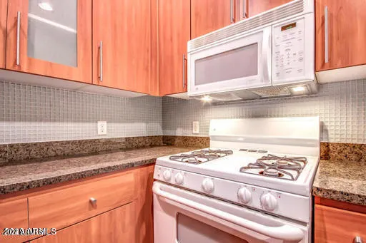 a kitchen with granite countertop cabinets and a stove top oven