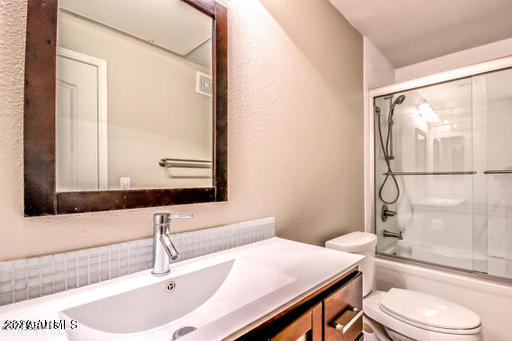 6900 East Princess Drive, Unit 2159 Phoenix, AZ 85054 - Photo 15 of 17 a bathroom with a granite countertop sink toilet a mirror and shower
