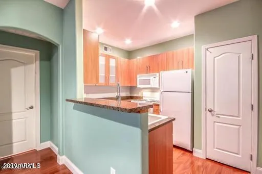 a kitchen with refrigerator cabinets and wooden floor